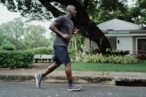 Old black man jogging slowly in the neighborhood