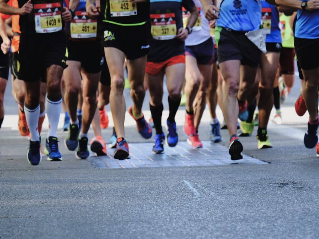 Lower body of a group of people running a marathon