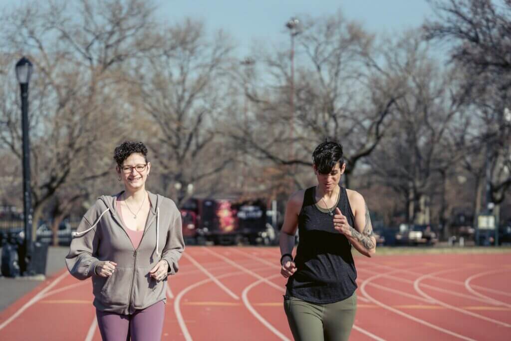 Woman preparing for a marathon on a track with a friend