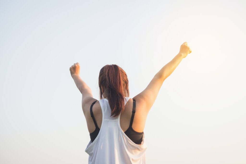 Woman putting her hands in the sky and happy to have accomplished something