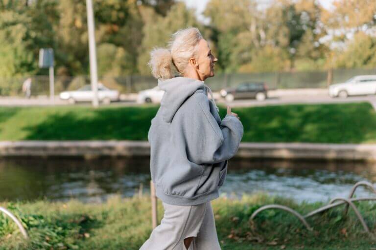 Old woman running slowly with a grey hoodie