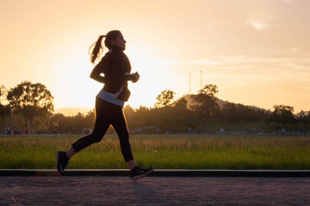 Woman running with sun in background