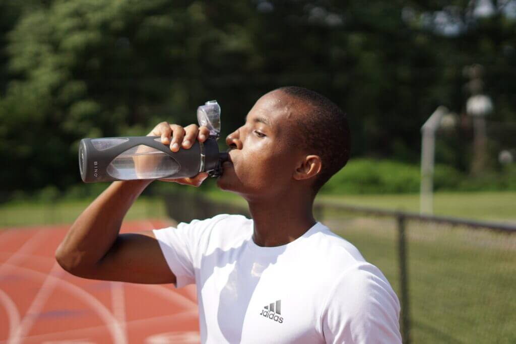 Young man drinking water after a long run