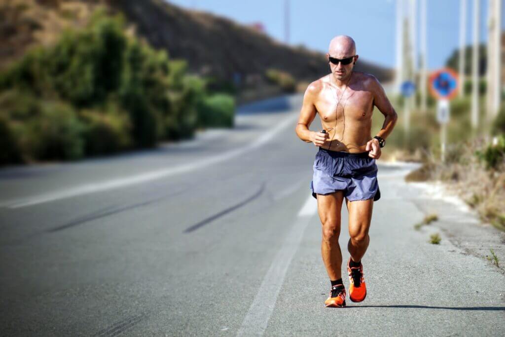 Old man running in the middle of the road shirtless