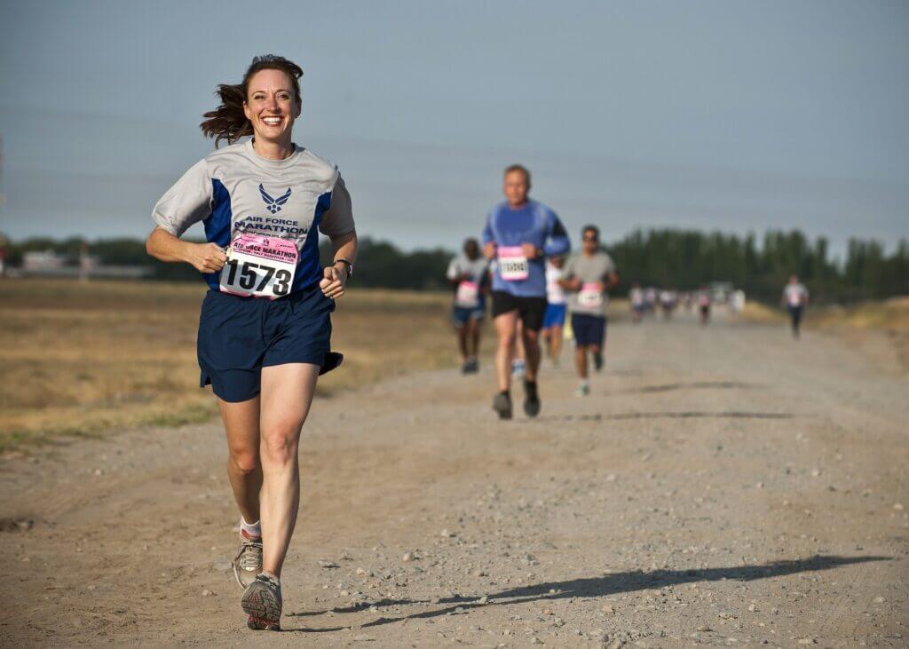 Woman running a marathon with a big smile on here face