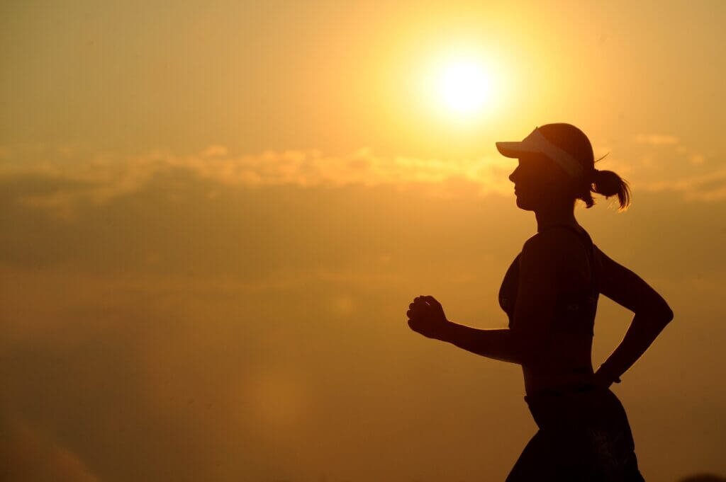 Woman training for a run during sunset