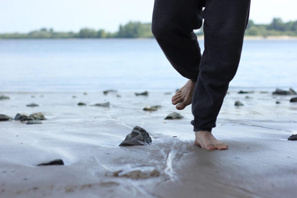 Man running barefoot on rocks