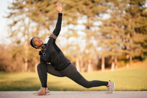 Black female athlete stretching and warming up before a run