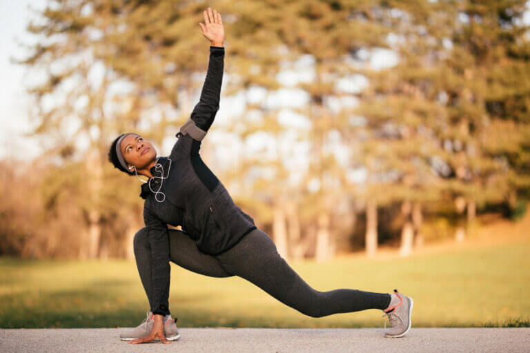 Black female athlete stretching and warming up before a run