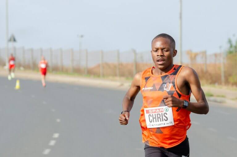 Man in Orange Tank Top Running on a Marathon