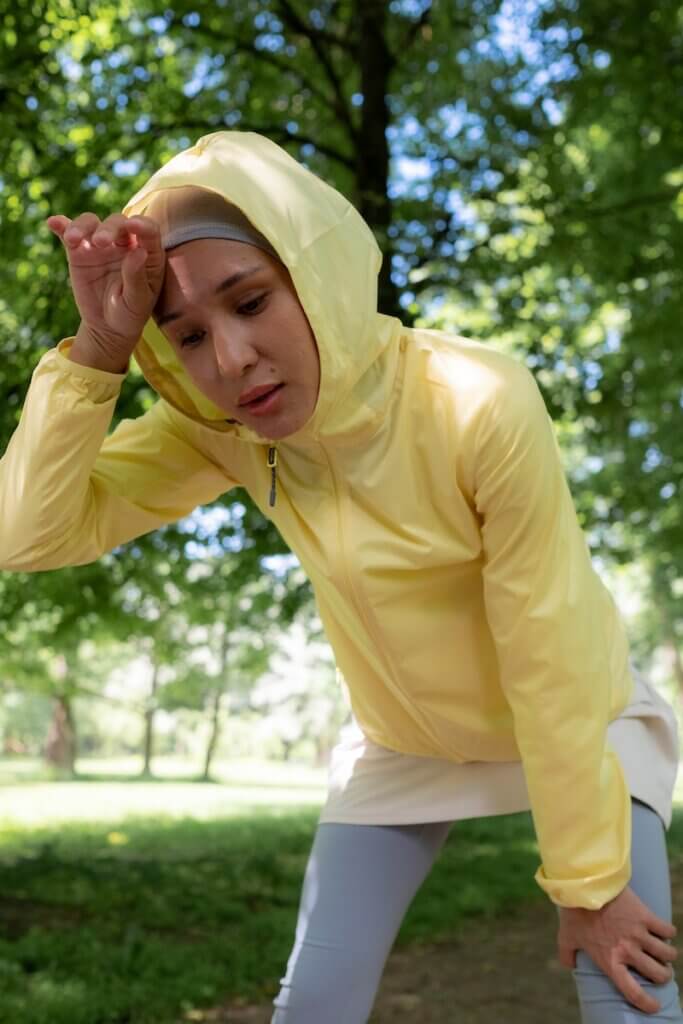 A Woman in Yellow Hoodie Jacket tired after running a long distance