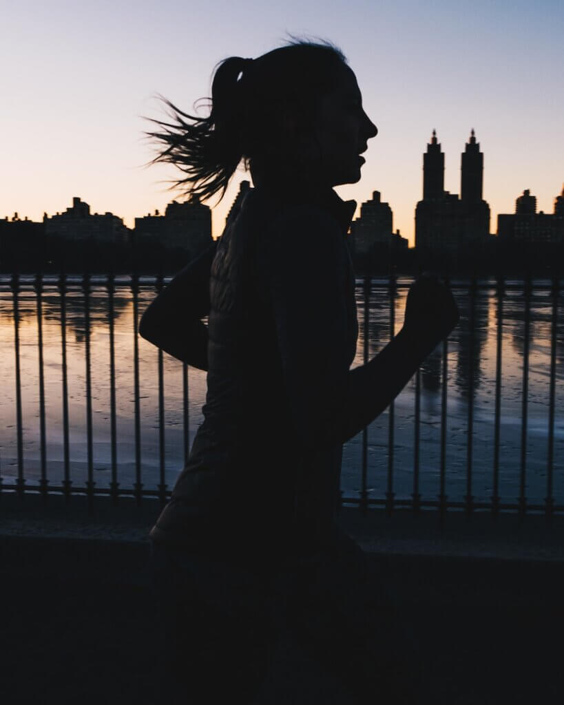silhouette photo of woman running at night
