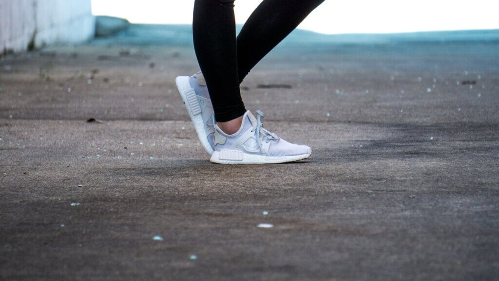 shallow focus photo of person wearing gray running shoes