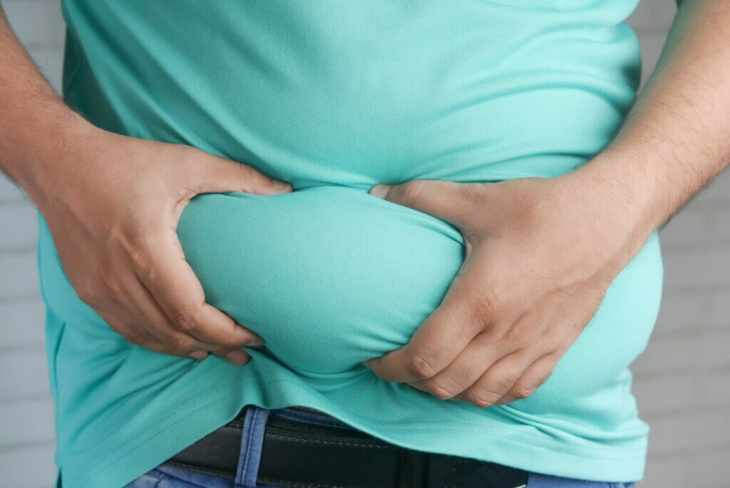 a man holding his stomach with his hands and checking for weight loss